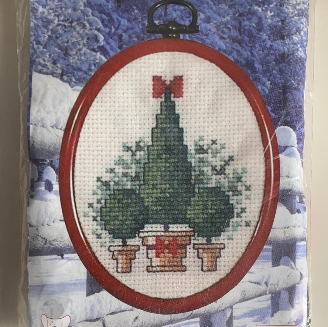 Christmas picture cross-stitches with oval frame and hanger.